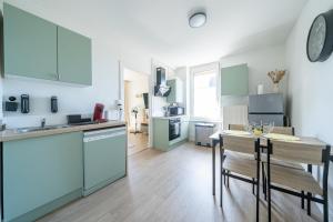 a kitchen with blue cabinets and a table with chairs at Le Julie -Spacieux - 5 pers' - 3 beds - Gare 500m in Homécourt