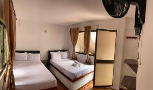 a bedroom with two beds and a mirror at Hotel la Isabella SM in Villeta +5 photos
