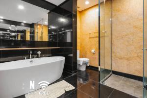 a bathroom with a bath tub and a toilet at Designer Luxury 3BR Retreat near Pavilion & KLCC in Kuala Lumpur +25 photos