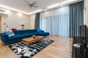 a living room with a blue couch and a table at Designer Luxury 3BR Retreat near Pavilion & KLCC in Kuala Lumpur