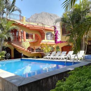 a hotel with a swimming pool in front of a building at Sol y luna cieneguilla in San Antonio