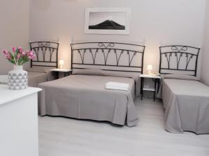 a bedroom with two beds and a vase of flowers at Pietra Pomice Hotel in Canneto