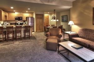 a living room with a couch and a table and a kitchen at Grand Timber Lodge in Breckenridge