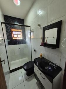 un bagno con wc, lavandino e doccia di Apartamento centro a Búzios Altre 3 foto