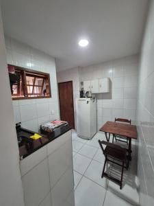 una piccola cucina con tavolo e frigorifero di Apartamento centro a Búzios