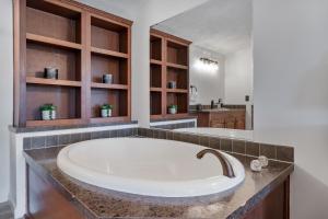 a large white tub in a bathroom with a sink at Watkins Glen Hot Tube Retreat- Finger Lakes Region in Burdett +51 photos