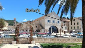 a building with a marina with palm trees in front of it at Roko's in Hvar