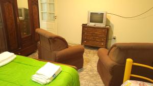 a room with two chairs and a tv on a dresser at El Rincón del cactus in San Rafael