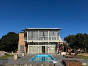 a house with a swimming pool in front of it at Apartamento de frente para lagoa -Ap 101 in Laguna +20 photos
