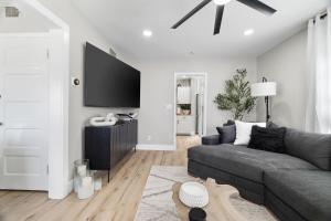 a living room with a gray couch and a flat screen tv at Craftsmen Gem 2-br House Walk Whiskey Rowsleep 6 in Prescott