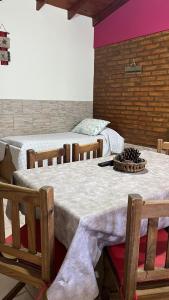 a room with three beds with a table and chairs at Cabañas bajos medanales in Victorica +32 photos