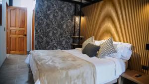 a bedroom with a large bed with white sheets and pillows at Hotel La Casa de Laurita in Salento