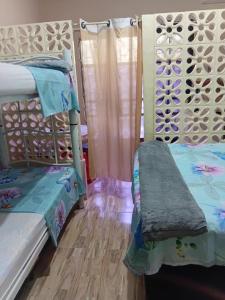 a bedroom with two bunk beds and a wooden floor at CANTINHO SÃO PEDRO in Maceió