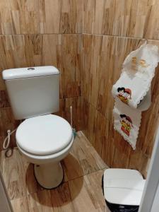 a bathroom with a white toilet and some towels at CANTINHO SÃO PEDRO in Maceió