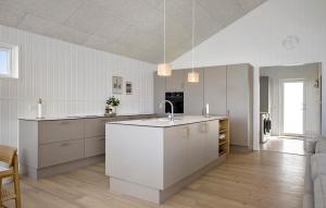 cocina grande con armarios blancos y fregadero en Pet Friendly Home In Saltum With Sauna, en Saltum