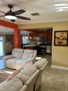 een woonkamer met 2 witte banken en een keuken bij Blue Orchid Palms in Nassau