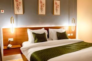 a bedroom with a large bed with white sheets and pillows at Condos De La ChiChi in Kumasi