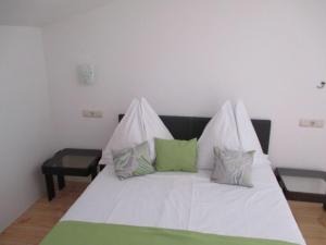 a white bed with green and white pillows on it at Guest House Villa Daniel - Two Bedroom Apartment with Balcony in Omiš