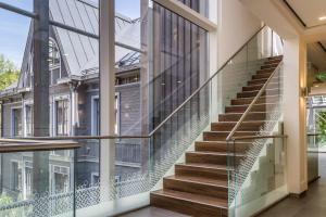 una escalera de cristal en un edificio con barandilla de cristal en Osobnyak, en Jūrmala