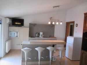 a kitchen with a counter and stools in a room at Guest House Villa Daniel - Two Bedroom Apartment with Balcony in Omiš