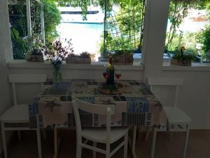 - une table à manger avec une bouteille de vin dans l'établissement Guest House Green Corner Supetarska Draga - Double Room With Balcony and Sea View, à Rab 29 autres photos