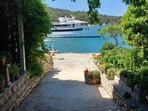 un bateau de croisière dans l'eau avec une passerelle et un bateau dans l'établissement Guest House Green Corner Supetarska Draga - Double Room With Balcony and Sea View, à Rab
