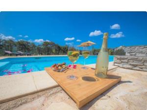 una mesa con dos copas de vino junto a una piscina en Villa P - Holiday Home, en Šibenik 8 fotos más