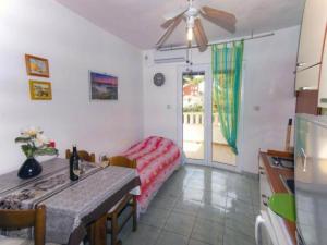 eine Küche mit Tisch und ein Esszimmer mit Deckenventilator in der Unterkunft Beachfront Apartments Pla a - Two Bedroom Apartment A2 in Ivan Dolac