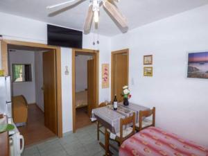 ein Wohnzimmer mit einem Tisch und einem Deckenventilator in der Unterkunft Beachfront Apartments Pla a - Two Bedroom Apartment A2 in Ivan Dolac