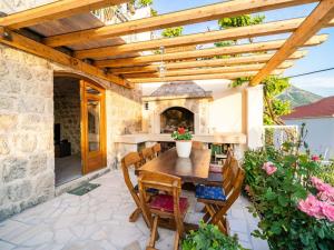 a patio with a wooden pergola and a table and chairs at Apartment Fortuno - One Bedroom Apartment with Terrace and Sea View in Mlini