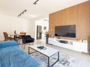 a living room with a blue couch and a tv at Holiday Home Iva - Three Bedroom Holiday Home in Šibenik