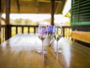 two glasses of white wine sitting on a wooden table at Holiday Home MILa - Duplex one bedroom Holiday Home with Terrace in Stubicke Toplice