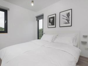 a white bedroom with a large bed and two pictures on the wall at Holiday Home Arbaro - Three Bedroom Holiday Home with Pool in Kravarsko +44 photos