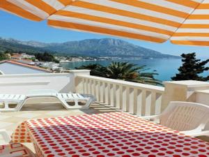 a table and chairs on a balcony with an umbrella at Apartments Pansion Franka 3 - Apartment 11 in Brist