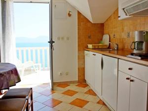 a kitchen with white cabinets and a view of the ocean at Apartments Pansion Franka 3 - Apartment 11 in Brist