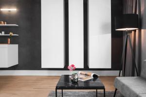 - un salon avec un mur noir et une table basse noire dans l'établissement AMANO HOME Apartments, à Berlin 22 autres photos