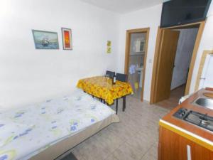 a bedroom with a bed and a table and a stove at Beachfront Apartments Pla a - One Bedroom Apartment A3 in Ivan Dolac