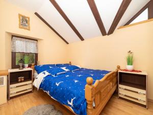 a bedroom with a blue bed and two night stands at Holiday home with hot tube and 1 room in Donja Stubica