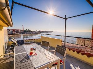 a table and chairs on a balcony overlooking the ocean at Sleek and Stylish Umag Apartments with Sea View - Comfort Two Bedroom Apartment with Terrace in Umag