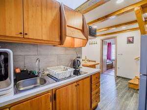 a kitchen with wooden cabinets and a sink at Sleek and Stylish Umag Apartments with Sea View - Comfort Two Bedroom Apartment with Terrace in Umag +18 photos