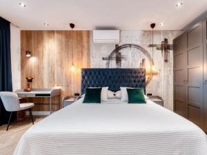 a bedroom with a large white bed with green pillows at Apartment with pool and hot tub in Cavtat +62 photos