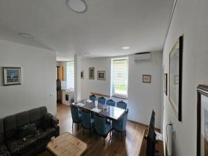 a living room with a table and blue chairs at Apartment Gracac - Two Bedroom Apartment with Terrace in Gračac