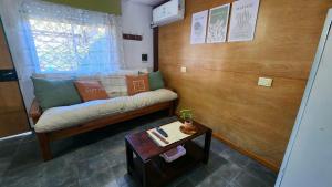 a living room with a couch and a table at Casa 2 ambientes con jardín y garage in Gualeguaychú