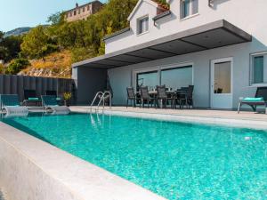 a swimming pool in front of a house at Spectacular Bol Island Sea View Villa with Pool - Four Bedroom Villa with Pool in Bol