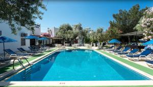 a swimming pool with chairs and umbrellas at Ali Baba Hotel Gümbet in Gümbet