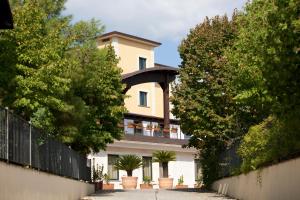 une grande maison avec une clôture et des arbres dans l'établissement Hotel Barbieri, à Altomonte