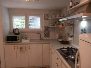 a kitchen with white cabinets and a stove top oven at Guest House Green Corner Palit - One Bedroom Apartment in Rab