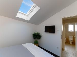 a white bedroom with a bed and a skylight at Holiday Home Lea - Three Bedroom Holiday Home with Terrace and Sea View in Maslinica