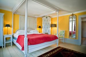 a bedroom with a large bed with a red blanket at Hotel Hellstens Malmgård in Stockholm