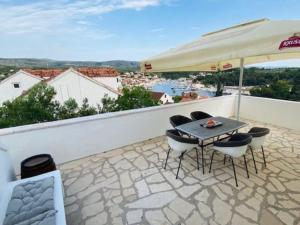 a patio with a table and chairs and an umbrella at Villa Brazza - Two Bedroom Apartment 1 in Milna